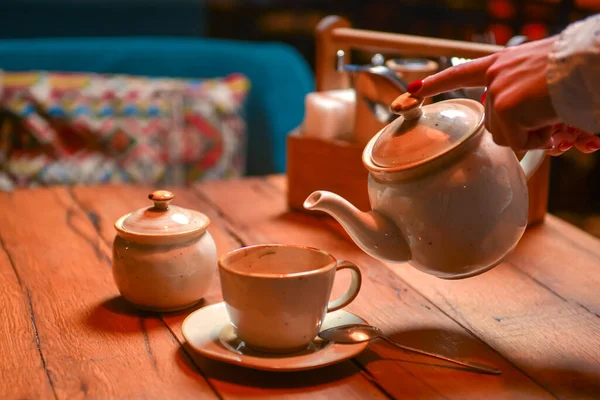 White tea set served on a rustic wooden table in a restaurant. Tea time. Ceramic tea set. Eating out concept.