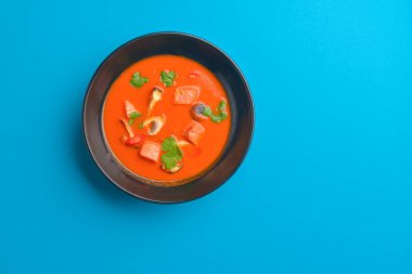 Mantarlı taze domates çorbası ve siyah kasede tavuk eti. Lezzetli yemek..