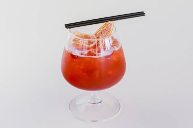 Buz ve portakallı soğuk yaz alkol kokteyli beyaz arka planda izole edilmiş küçük bir bardakta..