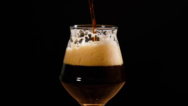 Dark beer is pouring into glass. IPA. Cold Beer in a glass with water drops. Craft Beer forming foam close up. — Stock Video