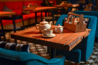 Restorandaki ahşap bir masada servis edilen beyaz çay seti. Çay zamanı. Seramik çay seti. Konsepti tüketiyorum.