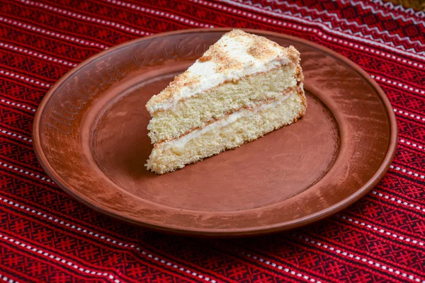 Смачний білий торт, ванільний торт, прикрашений збитими вершками. Подається на керамічній тарілці . — стокове фото