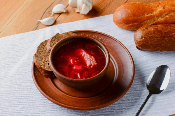 Traditional Ukrainian Russian soup, Borscht. Beetroot soup in bowl on wooden board and rustic wooden background — Stock Photo, Image