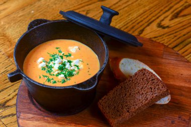 Kabak çorbası, peynir, et ve ahşap tahtada servis edilen ekmek kırsal ahşap masa üzerinde..