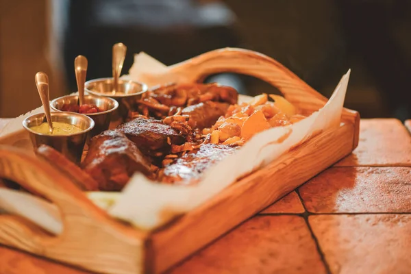 Heerlijke gegrilde gemarineerde steaks en geroosterde groenten van een zomerse BBQ op een houten plank in een restaurant. — Stockfoto