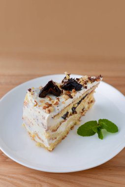 Beyaz bir tabakta servis edilen kuru erik, ceviz ve kremalı vanilyalı kek bisküvisi.