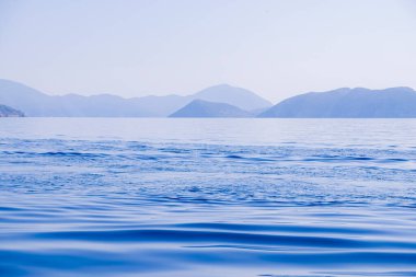 Huzurlu deniz manzarası. Sakin denizin üzerindeki güzel mavi gökyüzü ve güneş ışığı yansıması. Dalgalar. Huzur Uyumu.