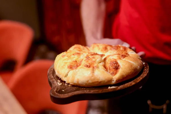 Close up of waiter serving a plate of Khachapuri - hachapuri in Adjarian. Waiter at work. Restaurant service. — Stock Photo, Image