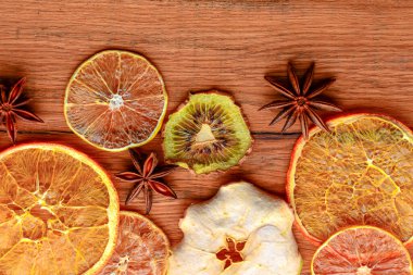 Dried orange, lemon, cinnamon sticks, anise star on rustic wooden background. Traditional mulled wine with spices.