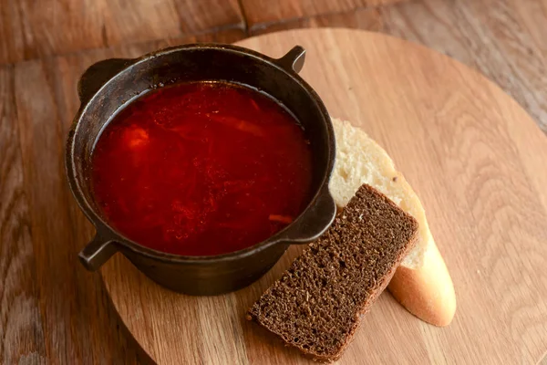 Традиційний український російський суп, Боршт. Бурячий суп у тарілці на дерев "яній дошці та сільському дерев" яному фоні. — стокове фото