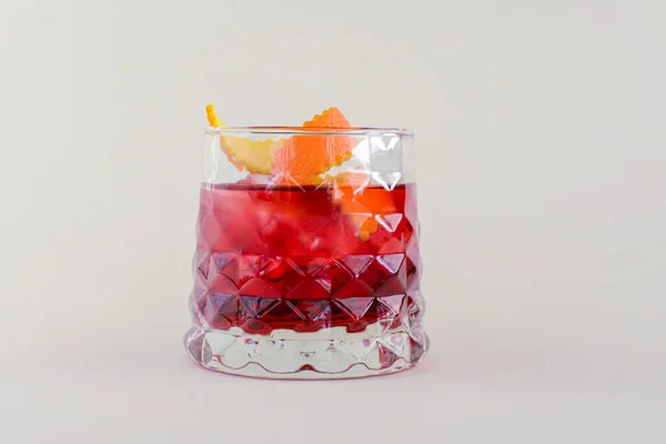 Zimno letni koktajl alkoholowy z lodem i pomarańczą w małej szklance na białym tle. — Zdjęcie stockowe