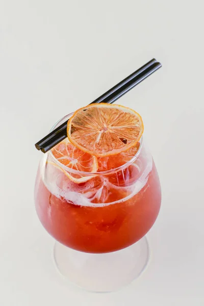 Холодный летний алкогольный коктейль со льдом и апельсином в небольшом стакане на белом фоне. — стоковое фото