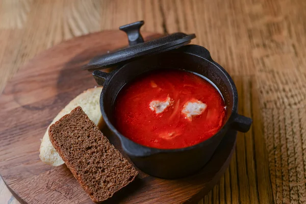 Традиционный украинский русский суп, борщ. Свекольный суп в миске на деревянной доске и деревенском деревянном фоне — стоковое фото