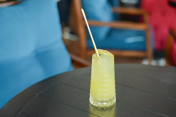 夏天的冷饮鸡尾酒，加冰和橙子，放在木制桌子上，餐厅背景模糊不清. — 图库照片
