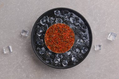 Eskimiş siyah metal tepside gri desenli bir kase kırmızı havyar. Üst görünüm, kopyalama alanı, düz uzanma.