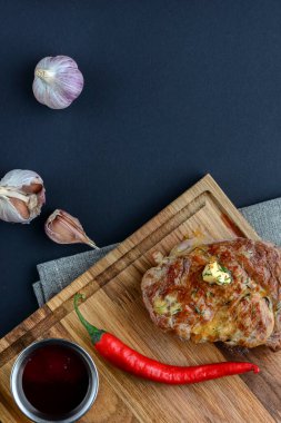 Siyah arka planda taze et bifteği ve rengarenk tahta üzerinde baharatlar. Üst görünüm, düz görünüm, boşluk afişini kopyala.