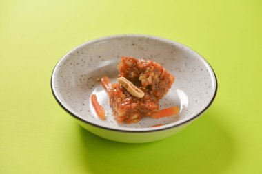 Roman ve fındık tatlısı. Pastel yeşil arka planda tatlı karamel tatlısı. Lezzetli yemekler..