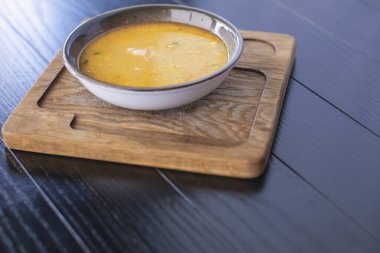 Tahta bir kasede sebzeli tavuk çorbası ve ahşap bir arka plan. Sağlıklı yemek.