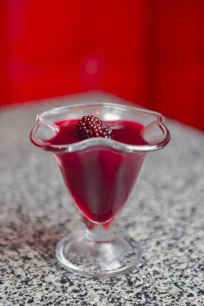 Geléia de cereja com framboesa servida em um copo alto em uma mesa de mármore sobre fundo embaçado . — Fotografia de Stock