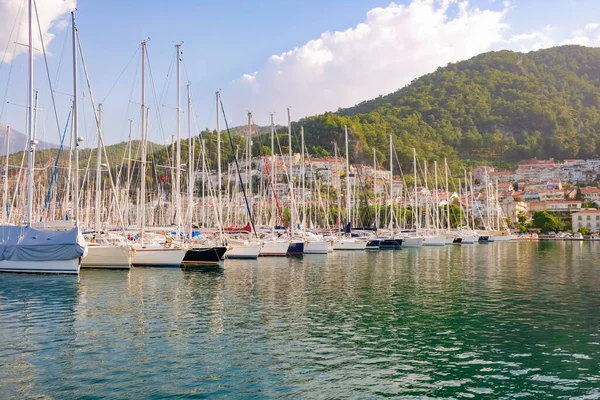 Luxury yachts docked in sea port at sunset. A stunning view of mega yachts in the port. Mountains background.