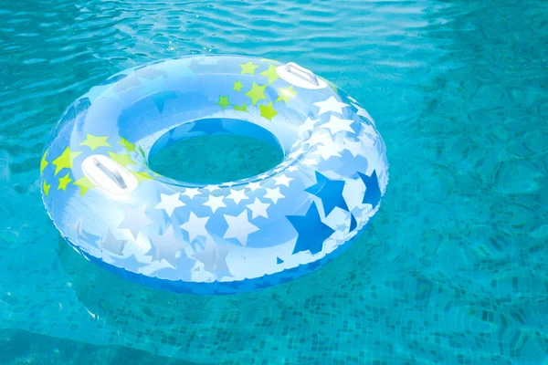Flotador azul y amarillo de la piscina, anillo flotando en una refrescante piscina azul. Piscina de natación vacía. Copiar banner de espacio . — Foto de Stock
