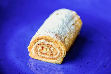 Bir tabak dolusu kremalı pasta. Mavi tabakta servis edilen lezzetli tatlı..