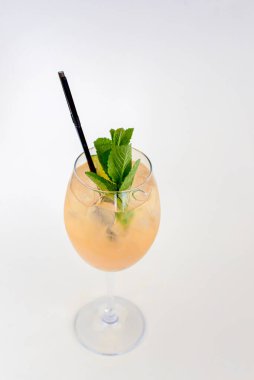 Buzlu ve portakallı soğuk yaz alkollü kokteyli beyaz arka planda izole edilmiş uzun bir şarap bardağında..