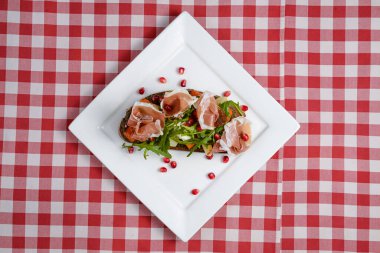 Kızarmış domatesli İtalyan aperatif bruschetta, mozzarella peyniri, sarımsak, otlar, prosciutto crudo ve sos..