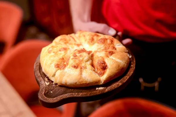 Close up of waiter serving a plate of Khachapuri - hachapuri in Adjarian. Waiter at work. Restaurant service. — Stock Photo, Image