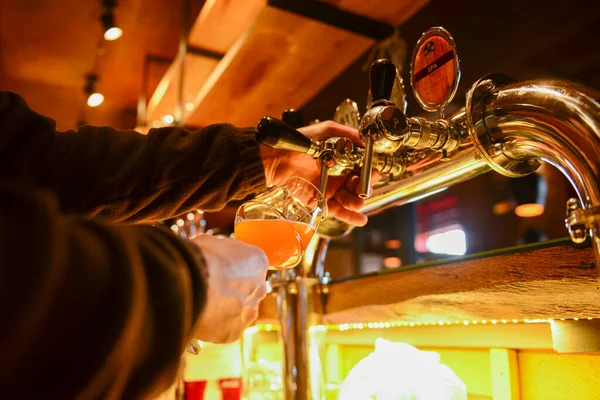 Pouring beer. Cropped image of bartender poring beer into the beer glass. — Stock Photo, Image