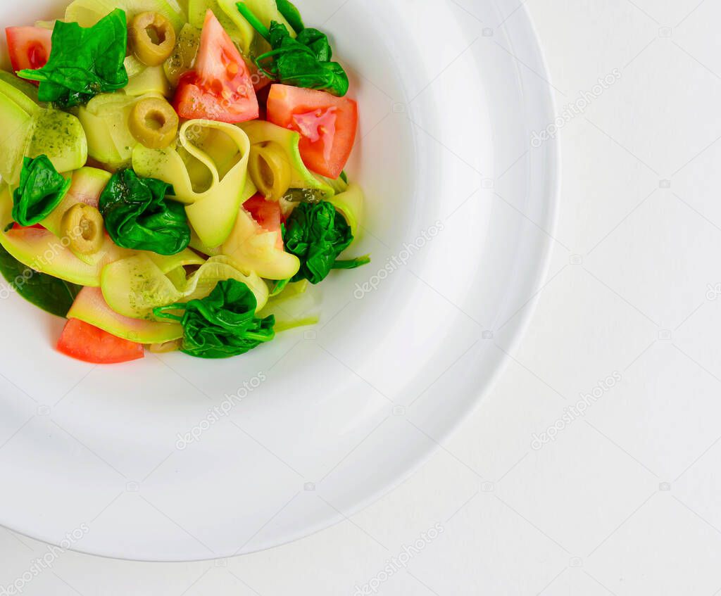 Vegetable pasta penne with asparagus,tomato and rucola in a white bowl. Close up. Copy space for text.
