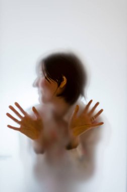 Buzlu cam arkasında karanlık kadın figürü