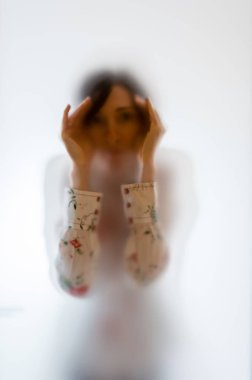 Buzlu cam arkasında karanlık kadın figürü