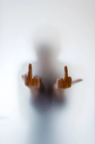 Figura borrosa de un hombre mostrando su dedo medio detrás de la escarcha — Foto de Stock