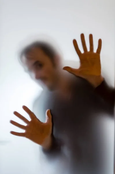 Shadowy human figure behind a frosted glass — Stock Photo, Image