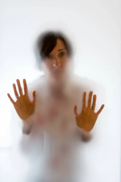 磨砂玻璃背后的阴暗的女人图 — 图库照片
