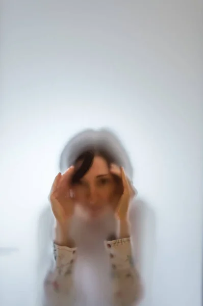 Shadowy woman figure behind a frosted glass — Stock Photo, Image