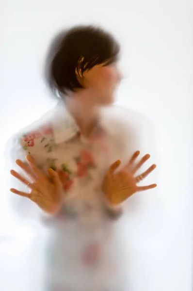 Shadowy woman figure behind a frosted glass — Stock Photo, Image