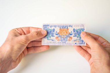 Bir Bhutan Ngultrum banknot elinde tutan adam