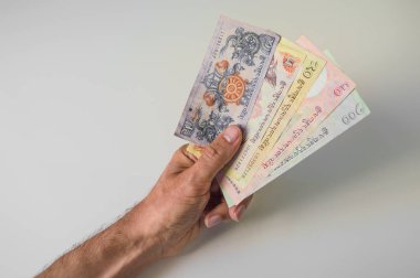 Bir sürü Bhutan Ngultrum banknot elinde tutan adam