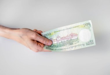 Yüz Bhutan Ngultrum banknot elinde tutan kadın