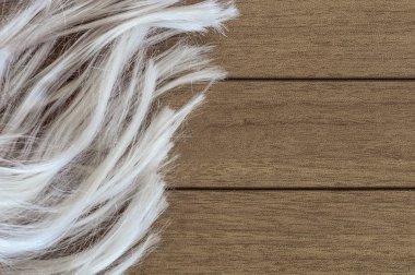 Ahşap arka plan üzerinde kadınsı uzun sarı peruk 