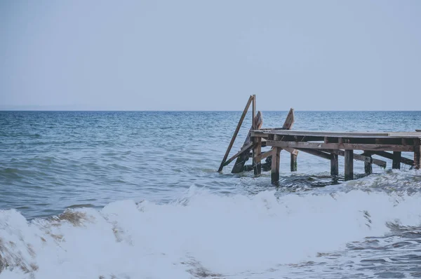 View of a wooden pier and seascape with running waves — Stock Photo, Image