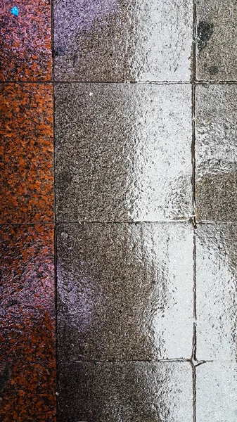 Pavimento húmedo de piedras rojas y grises — Foto de Stock