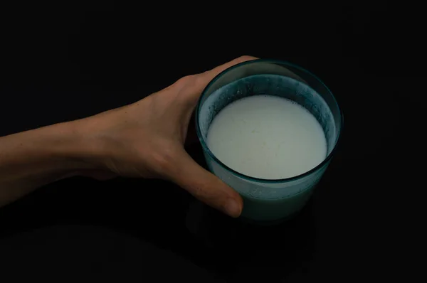 Woman hand holding a glass of kefir — Stock Photo, Image