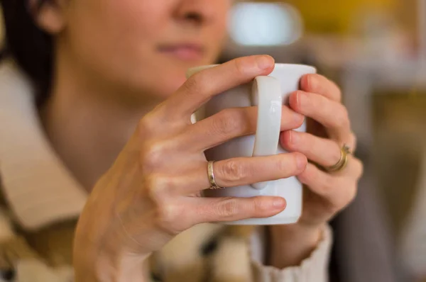 Delicadas manos de mujer caucásica sosteniendo una taza blanca . —  Fotos de Stock