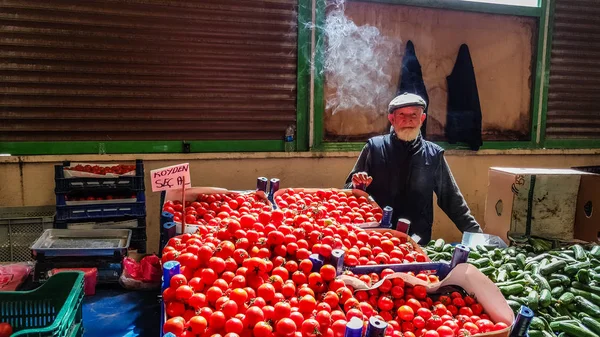 Eskisehir, Türkei - 25. Mai 2017: Alter Mann mit Rauch auf dem Kopf verkauft Tomaten und Gurken auf türkischem Lebensmittelbasar in eskisehir. — Stockfoto