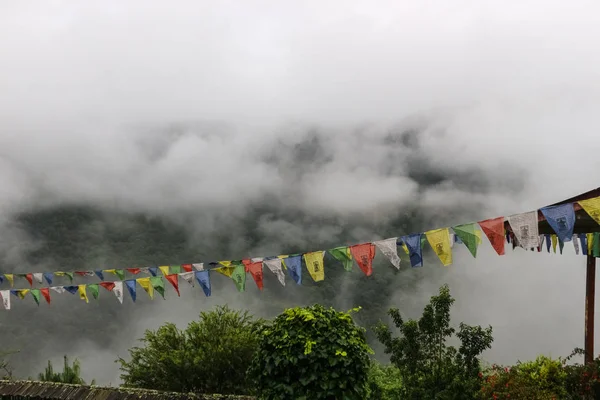 Vedere a steagurilor de rugăciune la Trongsa Dzong cu dealuri cețoase, Bumthang — Fotografie, imagine de stoc