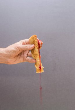 Beyaz adam el holding krep reçel ahşap kesme tahtası üzerinde sızıntı ile haddelenmiş