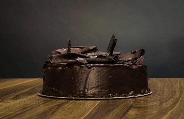 暗い背景においしいクリーミーな全体暗いチョコレート ケーキ — ストック写真